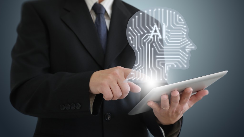 Person in a suit using a tablet with a glowing AI head icon, representing AI disclosure and transparency in sales conversations.